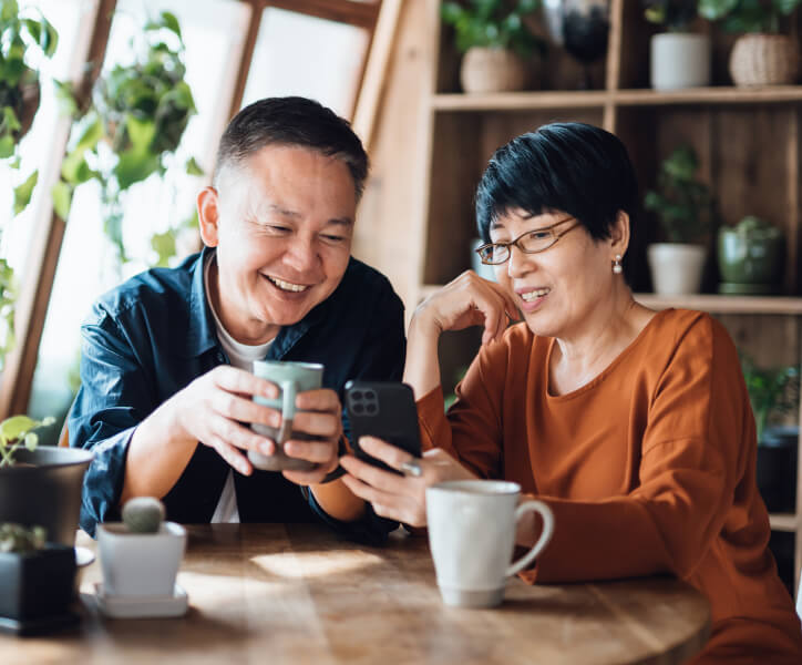 Older couple looking over online banking on devices