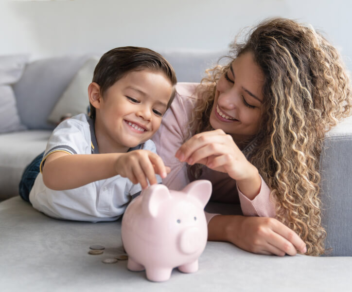 Mother and son putting money into piggybank