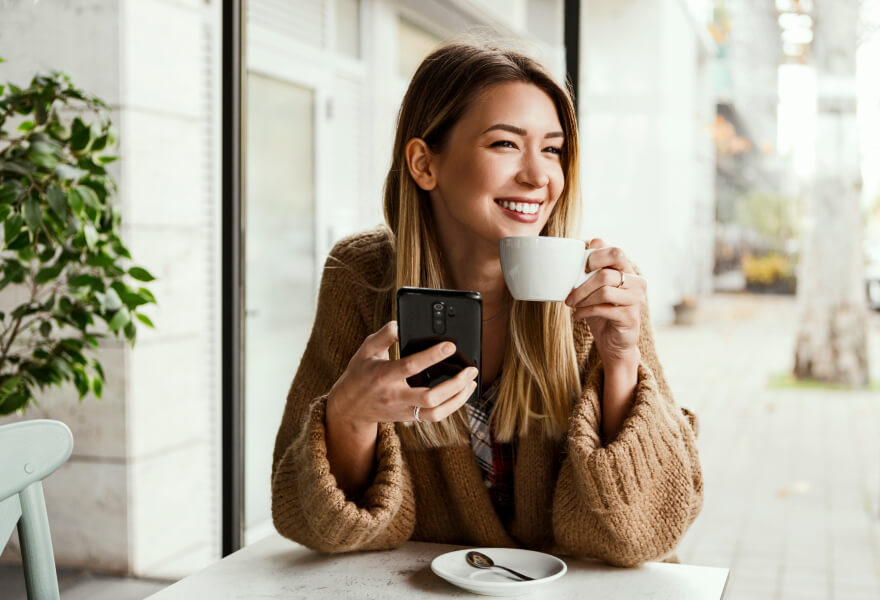 Woman with coffee looking at her mobile device